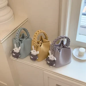 Women Mini Bucket Bag Braided Handle PU Leather Handbag Cute Doll Pendant Crossbody Bag for Daily Casual Use